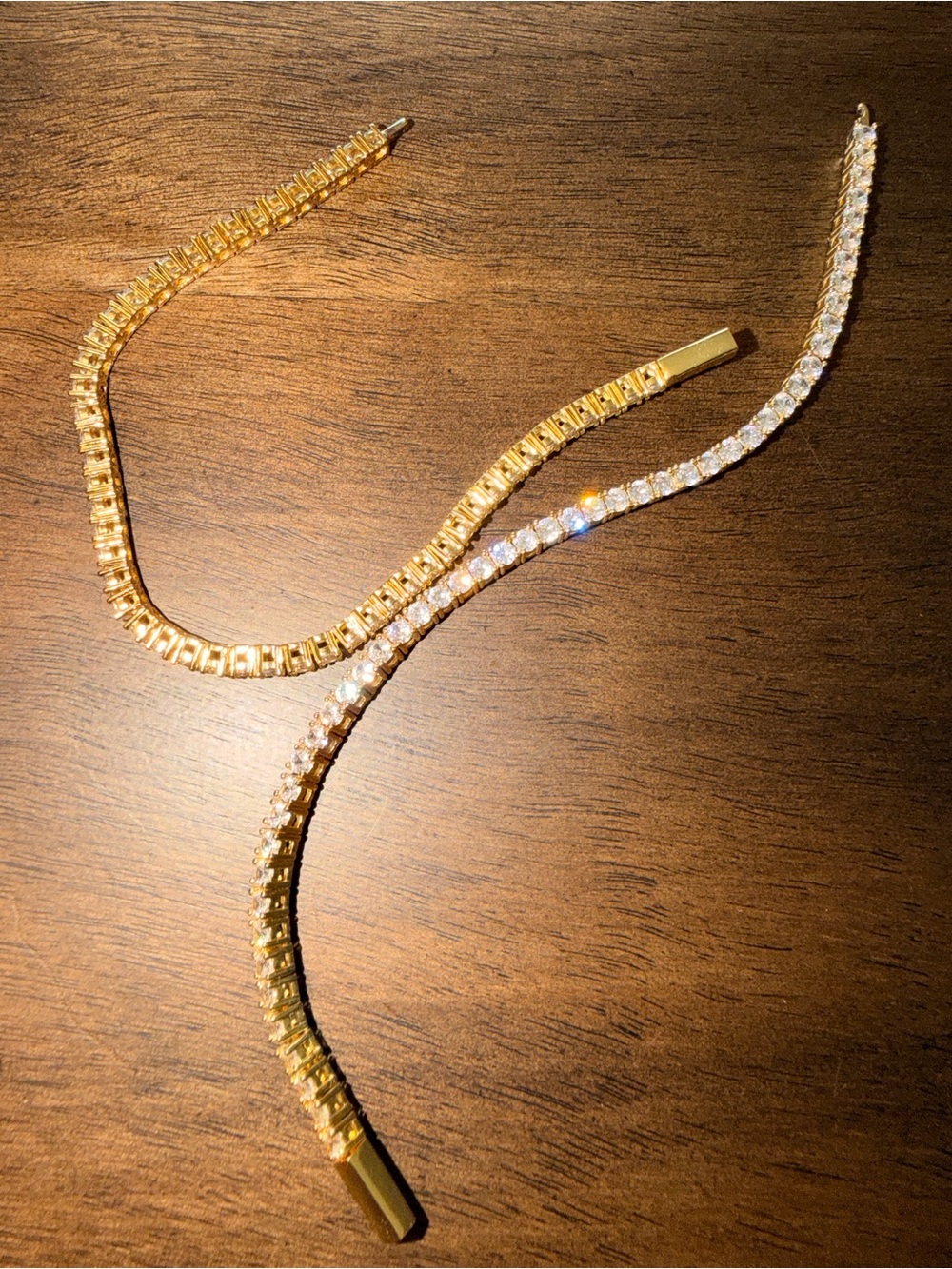 One gold tone tennis necklace. Two gold tone tennis bracelets. Lab diamonds.